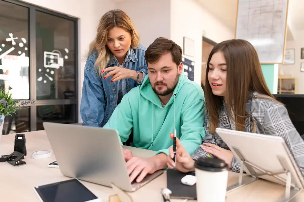 Inteligencia emocional en empresas. Equipo de trabajo en una oficina Un hombre y dos mujeres están trabajando frente a un computador en una oficina vestidos con ropa informal Equipo de trabajo en una oficina Un hombre y dos mujeres están trabajando frente a un computador en una oficina vestidos con ropa informal. Inteligencia emocional en empresas