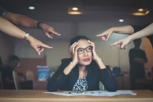 Personas señalando a una mujer en una empresa Cultura organizacional y seguridad psicológica 1