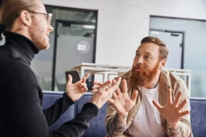 Conversación difícil Dos hombres conversando en una reunión de trabajo